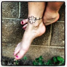 a woman's foot with a cross tattoo on it