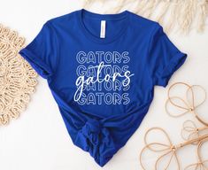 Show your team spirit with our trendy Gators shirt. Choose your shirt color, the colors for the design and we will do the rest. These are perfect for game day or showing your team spirit throughout the year. These make a great gift for teachers, family and friends. **Please note if you'd like a shirt color not shown in the photos, please choose custom and include desired shirt color in personalization notes. Shirts are made from 100% pre-shrunk cotton and are UNISEX sizes that run true to size. Gator Spirit Shirts, Baseball Onesie, Mascot Shirt, Gators Football, School Spirit Shirts, Spirit Shirts, Great Teacher Gifts, Teacher Svg