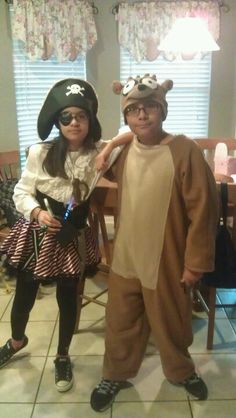 two children dressed up in costumes standing next to each other