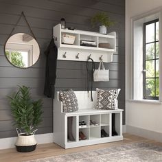 a white bench sitting under a mirror next to a window