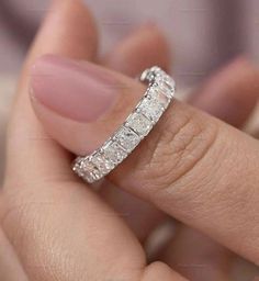 a woman's hand holding a diamond ring