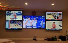 four large televisions mounted to the wall in a room with carpeted flooring