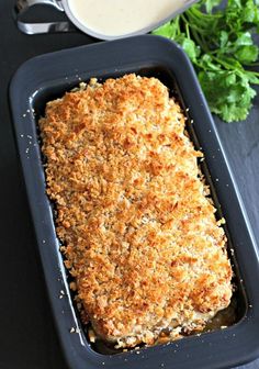 a casserole dish with bread crumbs in it next to a bowl of ranch dressing