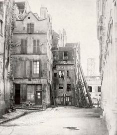 an old black and white photo of buildings with ladders on the side of them