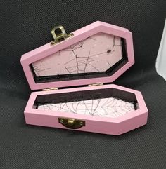 an open pink box with cracked glass inside