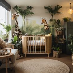 a baby's room with a giraffe mural on the wall next to a crib