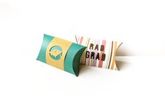 Two pillow boxes. One is turquoise with a gold band that has a grad cap cutout. The other is striped with cutout text reading Rad grad. Pillow Box Svg, Gift Holders, Box Designs, Pillow Styling, Big Gifts, Pillow Box, Grad Gifts, Svg Designs, Graduation Cap