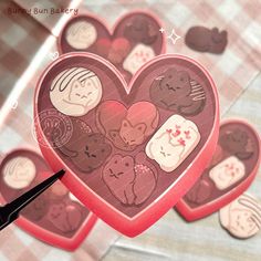 a heart shaped box filled with lots of stickers on top of a checkered table cloth