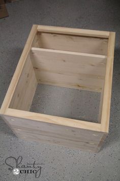 a wooden box sitting on top of a cement floor