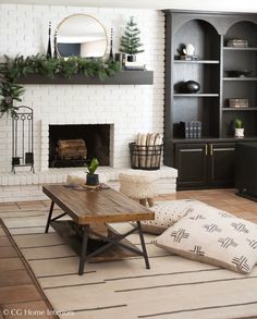 a living room with white brick fireplace and black bookcases