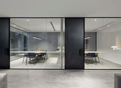 an empty room with chairs and tables in front of large glass doors that open up to the outside