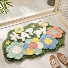 there is a rug with flowers on the floor next to slippers and a pair of shoes