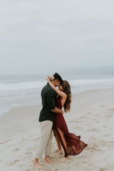 an engaged couple hugging on the beach