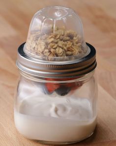 a glass jar filled with food on top of a wooden table