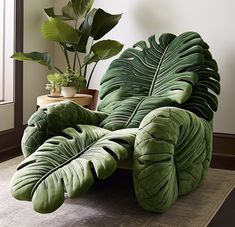 a large green leafy couch sitting on top of a rug next to a potted plant