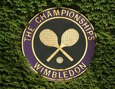 there is a sign that says the championships wimbledon on it and two tennis racquets