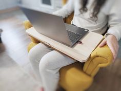 a woman sitting in a chair with a laptop on her lap