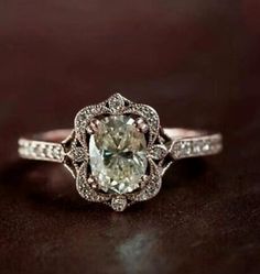 an engagement ring with a large green diamond in the center and white diamonds around it