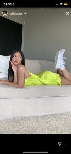 a woman in a yellow dress laying on a couch