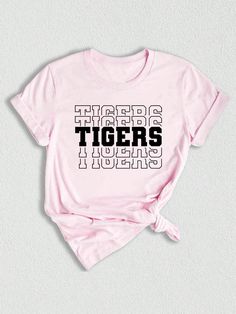 Introducing our Tigers Mascot Shirt, the perfect apparel for all the Tiger fans out there!  Whether you're a proud member of the Tigers team, a dedicated fan, or simply want to show your support, this shirt is a must-have addition to your collection. Designed with the iconic Tigers Mascot, this shirt captures the spirit and energy of your beloved team. Made with high-quality materials, this Tigers School Shirt is not only comfortable but durable as well. You'll love the softness of the fabric ag Fan Apparel T-shirt With Letter Print, School Spirit Short Sleeve T-shirt With Letter Print, School Spirit Graphic T-shirt Fan Gear, School Spirit Graphic T-shirt For Fan Gear, School Spirit Graphic Print T-shirt For Fan Gear, School Spirit Graphic T-shirt, College Sports Season T-shirt With Logo Print, College Sports Season Logo Print T-shirt, Fan Gear T-shirt With Letter Print, Crew Neck