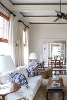 The stunning living room at Greatmen Cottage Vacation Rental Home in New Orleans, Louisiana, USA.  We see a couch by TCS, vintage rattan chairs and a round dining room table with integral Lazy Susan by Pierre Deux. Copper Countertops, Cottage Vacation, White Subway Tile