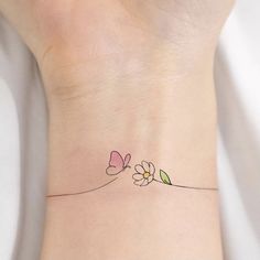 a woman's wrist with two flowers on the left side of her arm and one flower in the middle