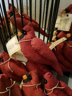 red stuffed birds are tied up with twine and labeled with words that read, birdie