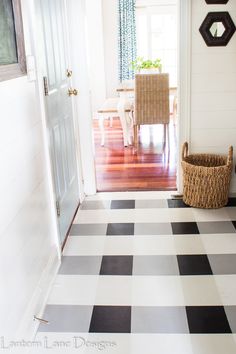 a black and white checkered floor with a basket next to it in front of the door