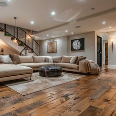 a living room filled with lots of furniture and a stair case in the back ground