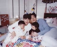 the family is posing for a photo on their bed