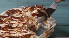 a piece of ice cream sundae with chocolate sauce and bananas on top, in a glass dish