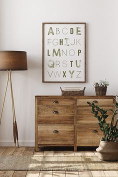 a wooden dresser sitting next to a lamp on top of a hard wood floor in front of a white wall