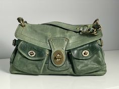 Coach Legacy Leigh Whiskey Distressed Leather Green Handbag w/ Brass Hardware Coach Legacy No. H0769-11128 Color: Green Leather with Brass Exterior: 1 Zipper Pocket/2 Open Slip Pockets Interior: 1 Zipper Pocket/Fabric Lining Legacy Multi-color Approximately: 14"w x 8.5"h x 4.5"d Original Retail Price: $658 30 Day Returns & Free Shipping La Apartment, Apartment Tour, Green Handbag, 2000s Fashion Outfits, Vintage Purses, Moving Out