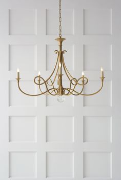 a chandelier hanging from the ceiling in a room with white paneled walls