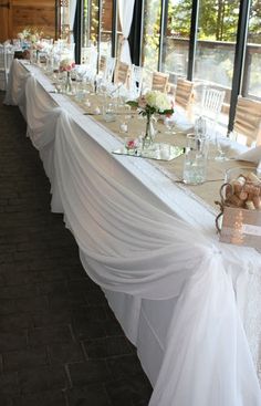 a long table is set up with white linens