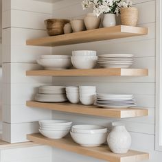 the shelves are filled with dishes and vases