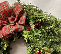 a christmas wreath with red berries and greenery