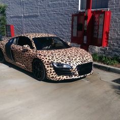 an animal print car parked in front of a building