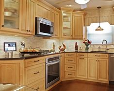 a kitchen with wooden cabinets and stainless steel appliances