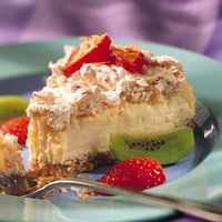 a piece of cheesecake on a plate with strawberries and kiwi