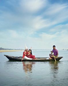 two people sitting in a boat on the water with one person holding an ice cream cone