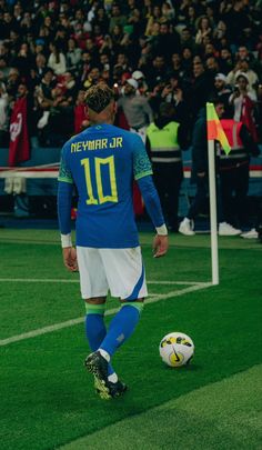 a soccer player is about to kick the ball in front of an audience at a sporting event