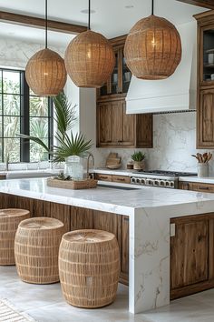 a kitchen with wooden cabinets and marble counter tops, hanging lights over the island area