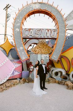 Celebrate love in style with this vibrant couple at a neon museum! 🌟 The bride dazzles in a timeless wedding dress, with her dark hair cascading in loose waves. Next to her, the groom rocks a classic tuxedo. The vintage "CASINO" sign and eclectic neon backdrop add a unique twist to their special day. Perfect inspo for those hunting for fun wedding ideas! 💕✨ #weddingideas #uniqueweddingideas #timelessweddingdress #simpleweddingdress #blacktiewedding Museum Proposal, Motel Design, Abroad Wedding, White Wedding Chapel, Vegas Wedding Venue, Vegas Engagement