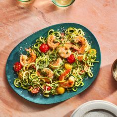 a blue plate topped with pasta and shrimp