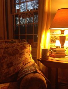 a living room with a couch, lamp and books on the table in front of it