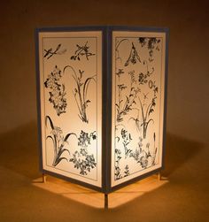 a lit up screen with flowers and birds on it, in the middle of a dimly lit room