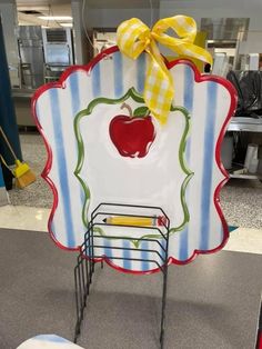 a shopping cart with an apple on it and a yellow ribbon hanging from the top