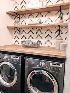 a washer and dryer sitting next to each other on top of a wooden shelf