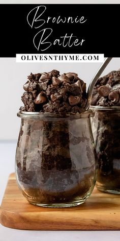 two jars filled with brownie batter and chocolate chips, on top of a wooden cutting board